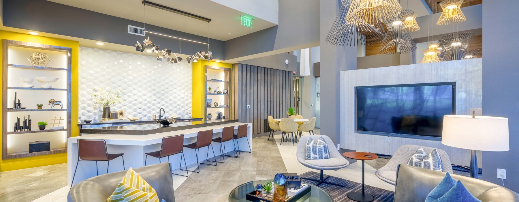 Resident clubhouse with ample seating, fireplace, demo kitchen and TVs