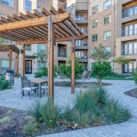 Welcome Home Outdoor lounge at Cadence at Frisco Station apartments in Frisco, TX, featuring outdoor seating and a fire pit.