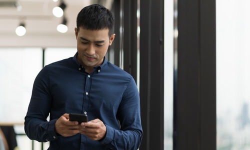 lifestyle image of a man on his smartphone outdoors